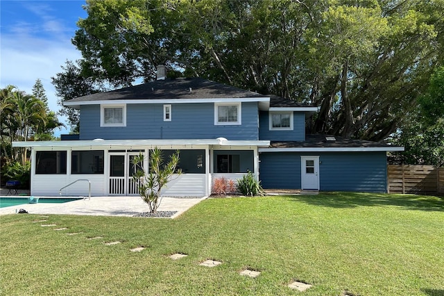 back of house with a sunroom, fence, an outdoor pool, and a yard