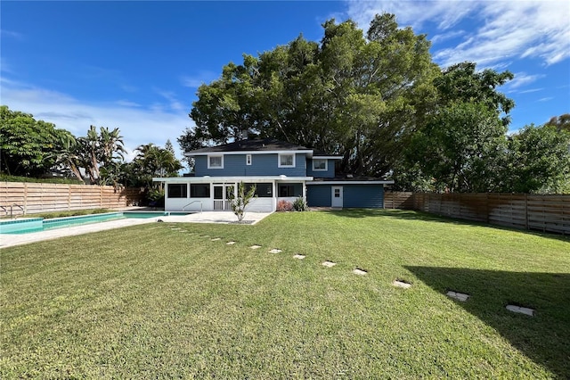 back of property featuring a fenced in pool, a sunroom, a fenced backyard, and a yard