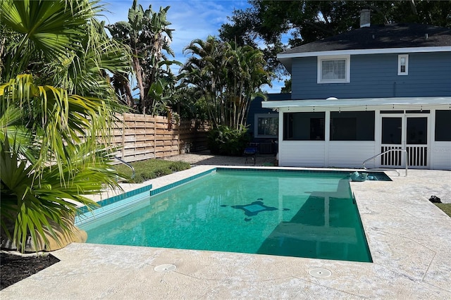 view of pool featuring a fenced in pool, a sunroom, a patio area, and fence