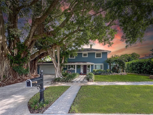 view of front of property featuring driveway, a front lawn, and a porch