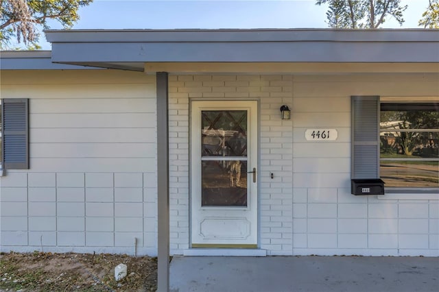 doorway to property featuring brick siding