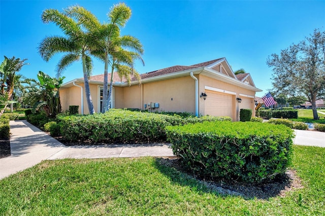 view of home's exterior featuring a lawn, an attached garage, and stucco siding