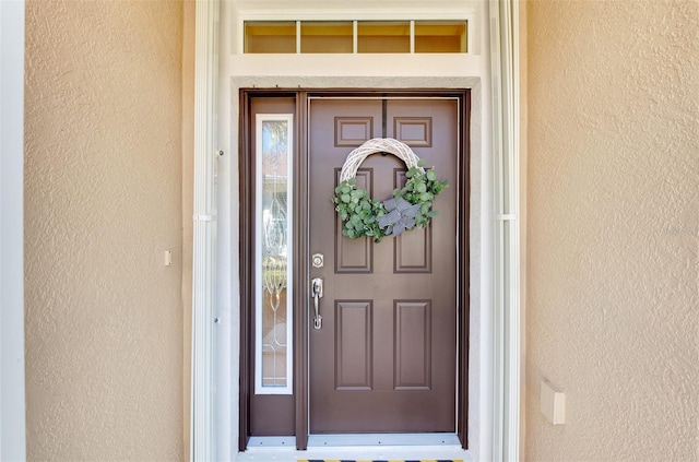 entrance to property featuring stucco siding