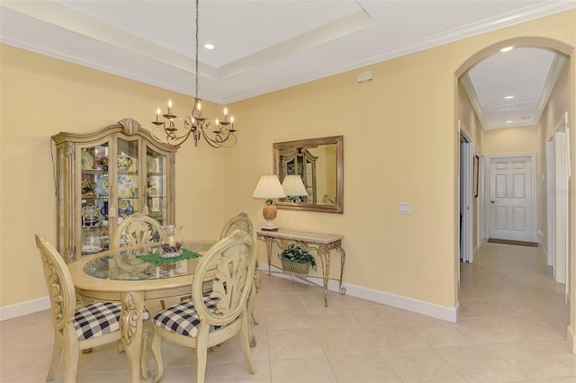 dining space featuring light tile patterned floors, baseboards, arched walkways, and a tray ceiling