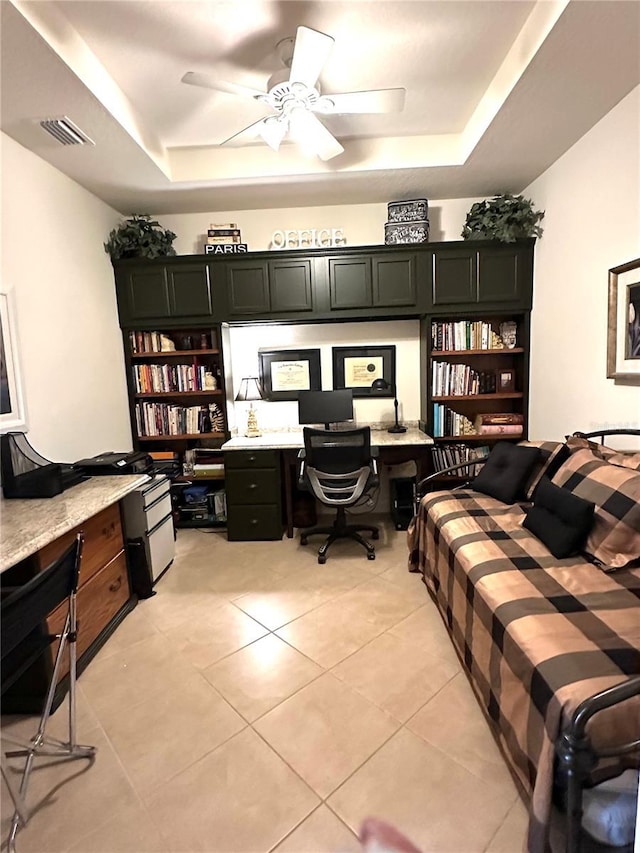 home office featuring light tile patterned floors, built in desk, a raised ceiling, and visible vents