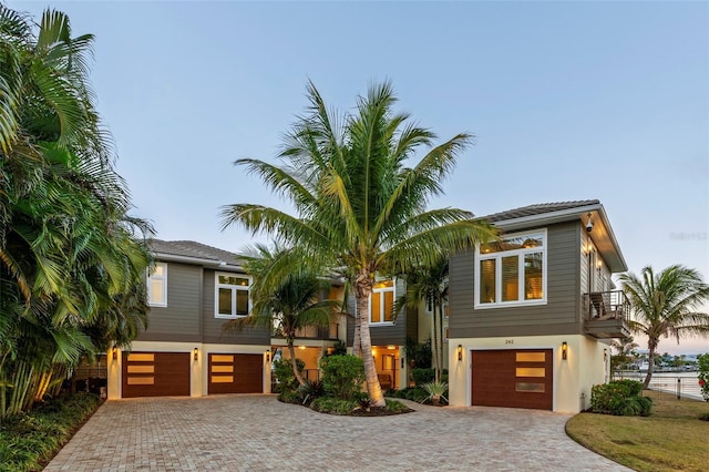 view of front of property featuring a garage, decorative driveway, and stucco siding