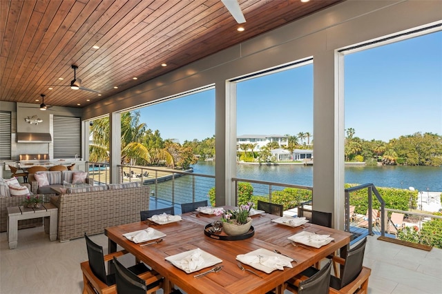 sunroom featuring a water view, wooden ceiling, and a ceiling fan