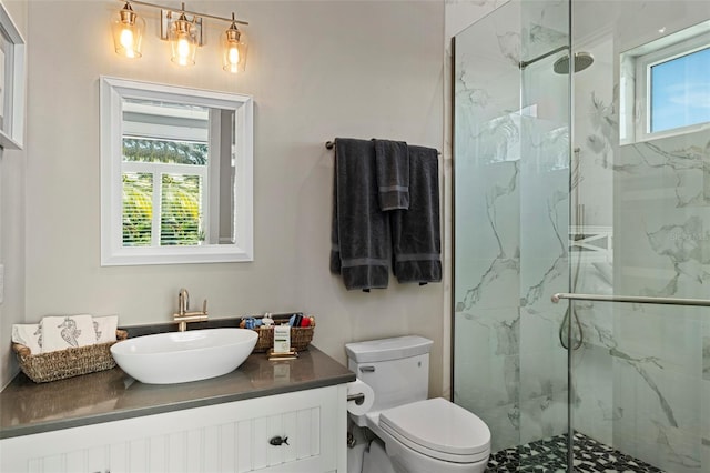 full bath featuring toilet, vanity, and a marble finish shower