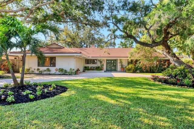 1610 S Lake Shore Dr, Sarasota, FL 34231 - ranch-style house featuring stucco siding, a chimney, a front yard, and fence