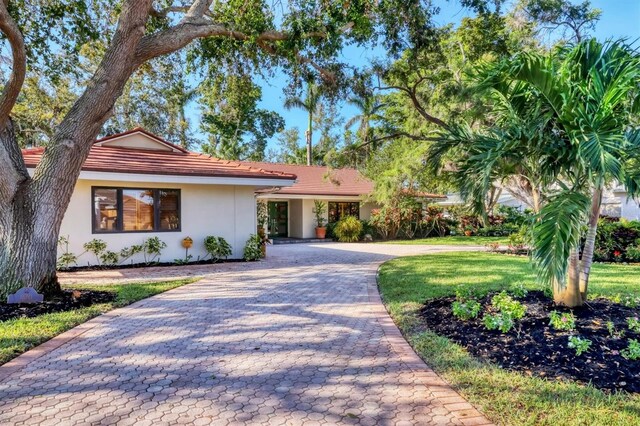 1610 S Lake Shore Dr, Sarasota, FL 34231 - view of front facade with stucco siding, decorative driveway, and a front lawn