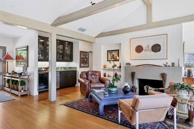 1610 S Lake Shore Dr, Sarasota, FL 34231 - living area with visible vents, light wood-style flooring, lofted ceiling with beams, a fireplace, and indoor wet bar