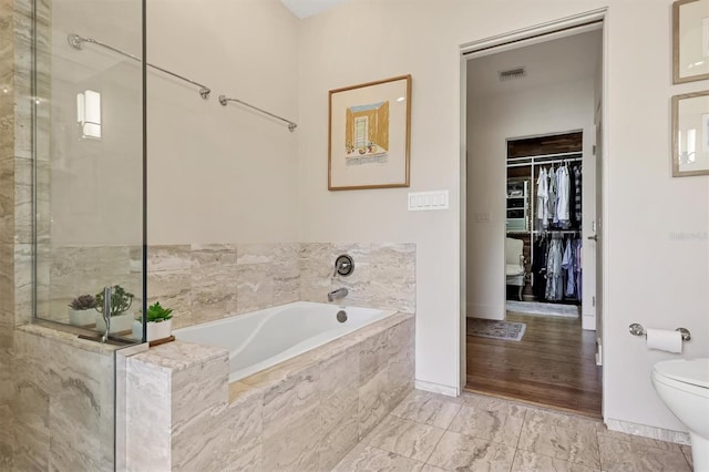 1610 S Lake Shore Dr, Sarasota, FL 34231 - full bath with a bath, visible vents, a walk in closet, toilet, and a shower with door