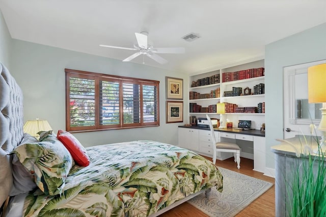1610 S Lake Shore Dr, Sarasota, FL 34231 - bedroom with visible vents, built in study area, a ceiling fan, and wood finished floors