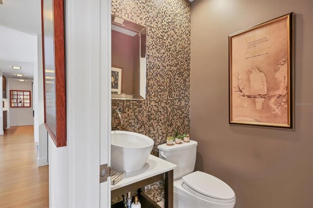 1610 S Lake Shore Dr, Sarasota, FL 34231 - half bath featuring toilet, tile walls, and wood finished floors