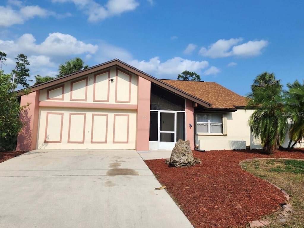 view of front of property with an attached garage, roof with shingles, concrete driveway, and stucco siding