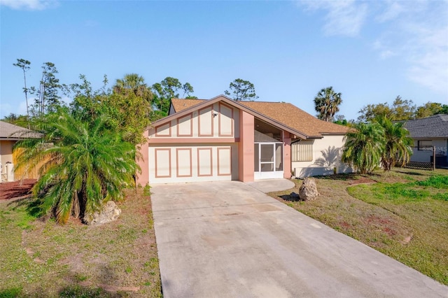 mid-century home with stucco siding, concrete driveway, a garage, and a front yard