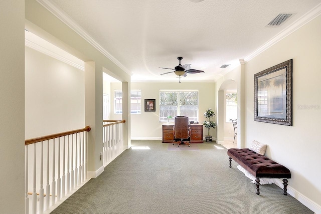 carpeted home office featuring ornamental molding, a ceiling fan, visible vents, and baseboards