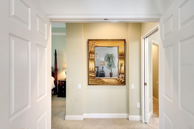 hallway featuring carpet floors and baseboards