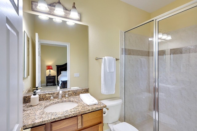 bathroom with toilet, a shower stall, ensuite bathroom, and vanity