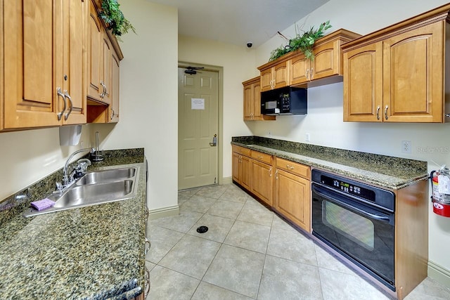 kitchen featuring brown cabinetry, light tile patterned flooring, a sink, and black appliances