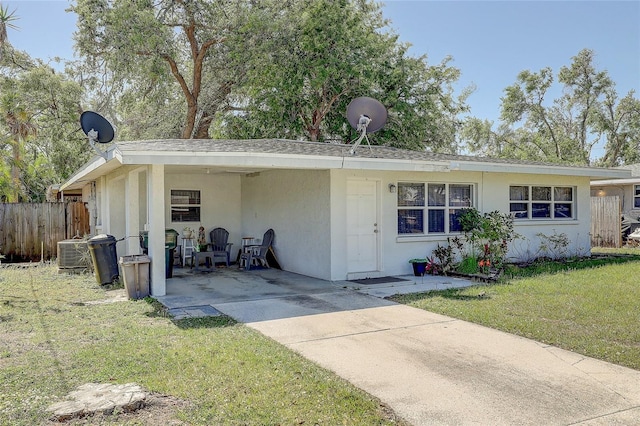 view of front of house with central AC, fence, a front lawn, and stucco siding