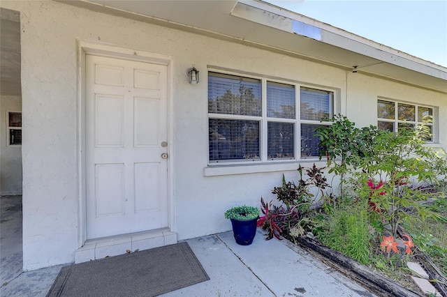 view of exterior entry featuring stucco siding