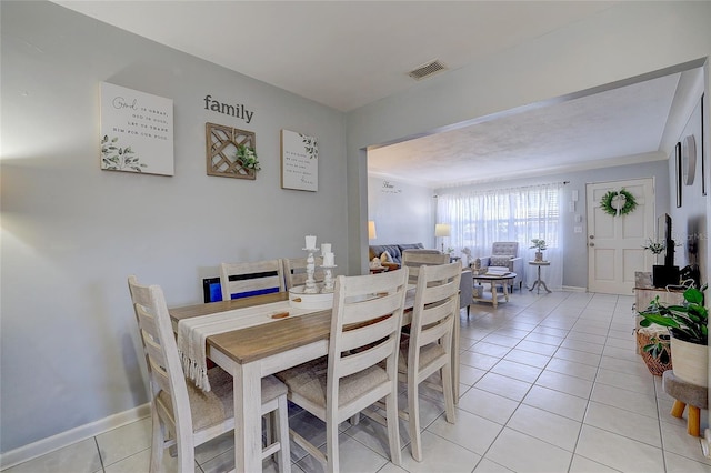 dining room with baseboards, visible vents, and light tile patterned floors
