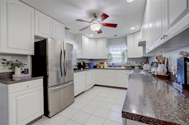 kitchen featuring dark countertops, freestanding refrigerator, and under cabinet range hood