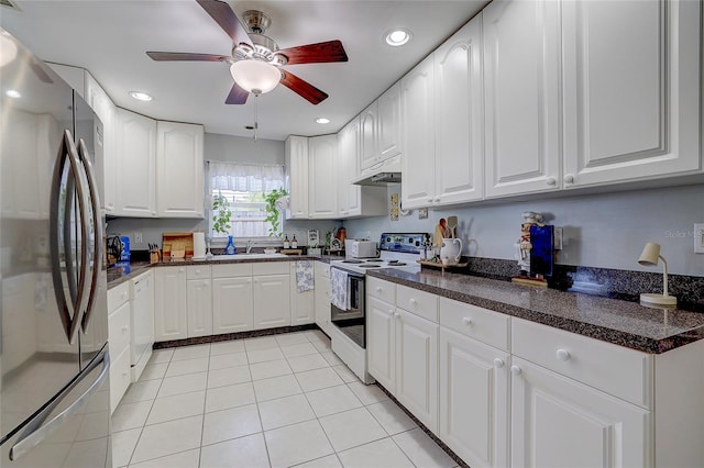 kitchen with dark countertops, light tile patterned flooring, under cabinet range hood, recessed lighting, and white appliances
