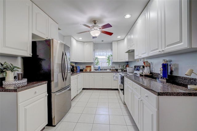kitchen with freestanding refrigerator, dark countertops, ceiling fan, light tile patterned floors, and range with electric cooktop