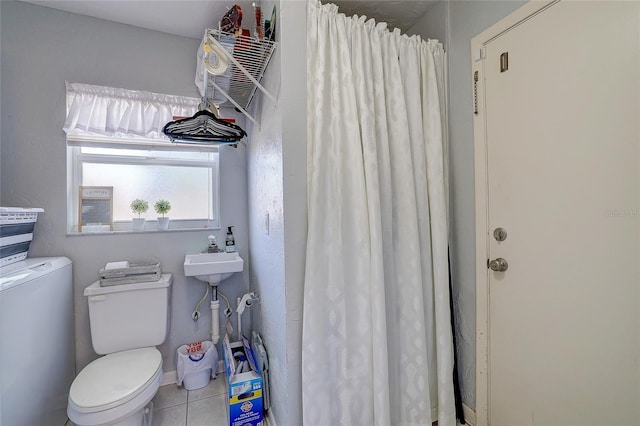 bathroom with a sink, a shower with curtain, tile patterned flooring, and toilet