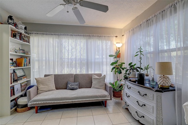 living area featuring a textured ceiling, ceiling fan, and light tile patterned floors
