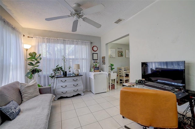 living room featuring a textured ceiling, a ceiling fan, light tile patterned flooring, and visible vents