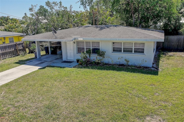 single story home featuring fence, a carport, concrete driveway, and a front lawn