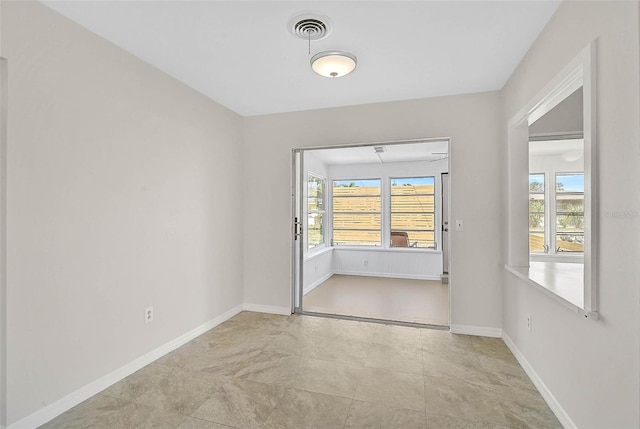 spare room featuring baseboards and visible vents