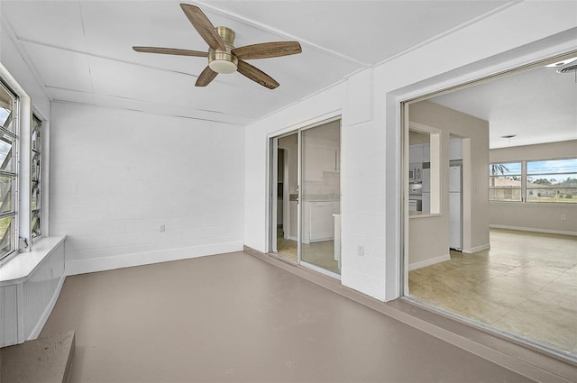 unfurnished sunroom featuring ceiling fan