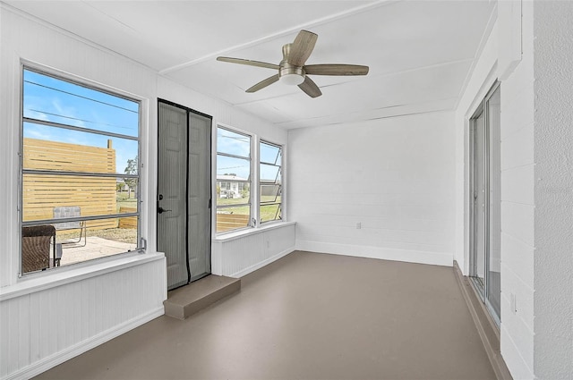 unfurnished sunroom with ceiling fan