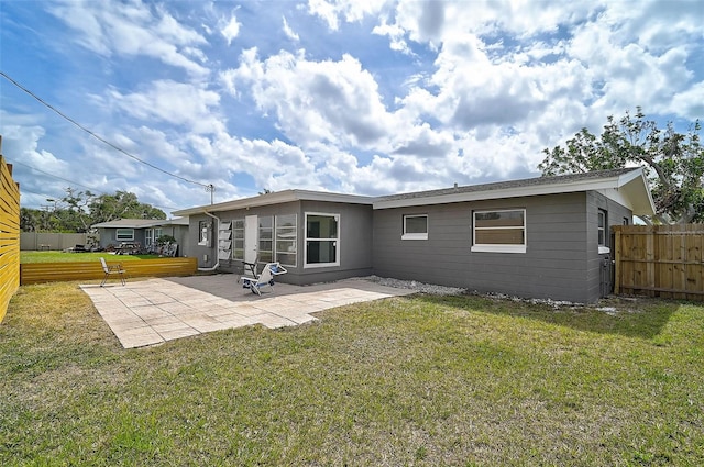 rear view of property featuring a patio area, fence, and a yard