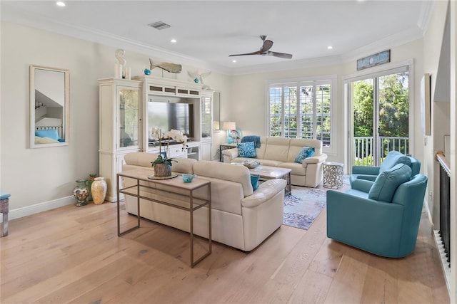 living area with crown molding, baseboards, visible vents, and light wood-style floors