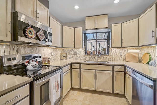 kitchen featuring tasteful backsplash, stainless steel appliances, a sink, and light countertops