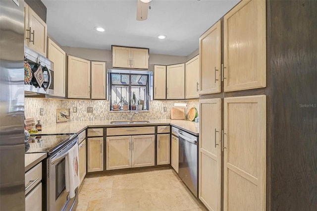 kitchen featuring stainless steel appliances, light brown cabinets, and a sink