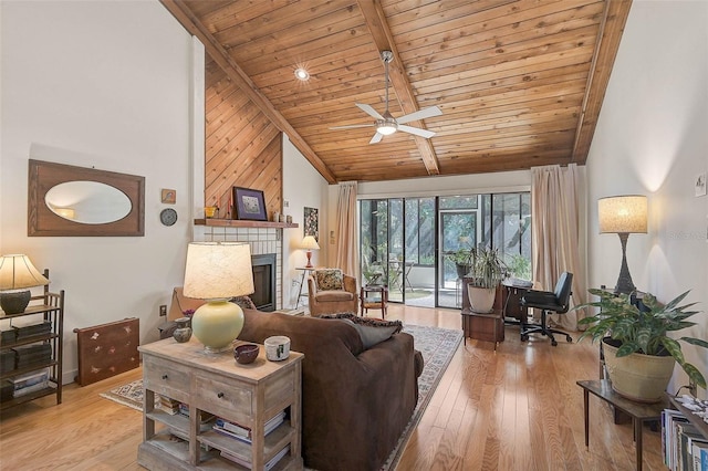 living room with high vaulted ceiling, a tile fireplace, wood finished floors, and wood ceiling