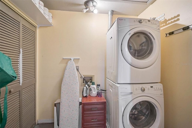 washroom featuring laundry area and stacked washer / dryer