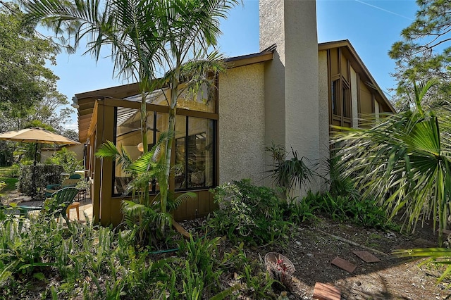 view of property exterior featuring a chimney and stucco siding