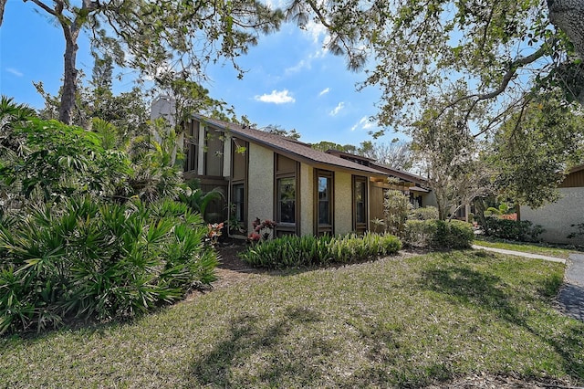 view of front of home with a front lawn and stucco siding