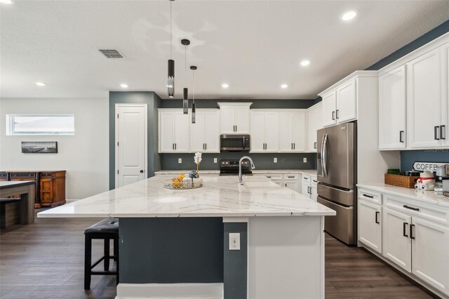 kitchen featuring dark wood-type flooring, visible vents, white cabinets, appliances with stainless steel finishes, and a kitchen bar