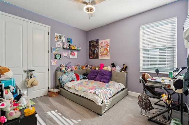 carpeted bedroom featuring ceiling fan, a closet, and baseboards