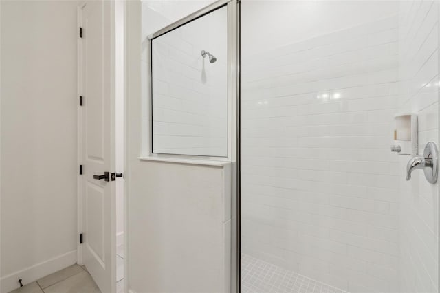 bathroom featuring a shower stall, baseboards, and tile patterned floors