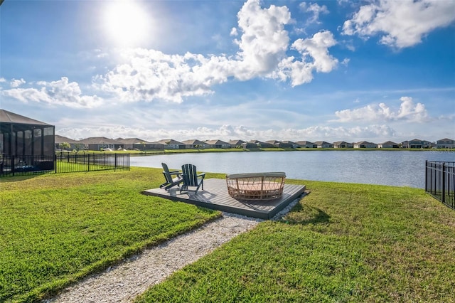 view of yard featuring a residential view, a water view, and fence