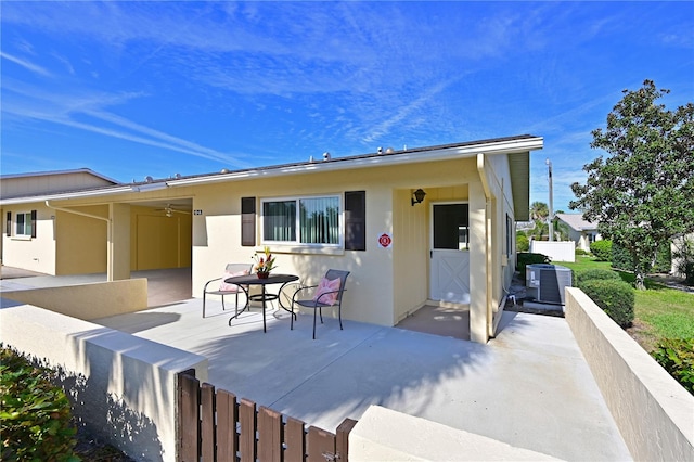 back of property with a patio, central AC unit, fence, and stucco siding